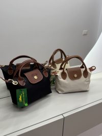 Longchamp Le Pliage Small bags in black and beige on display.