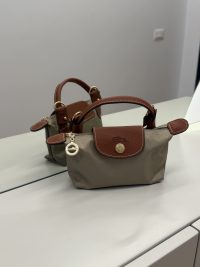 Longchamp Le Pliage XS handbag with brown leather accents.
