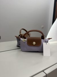 Purple Longchamp Le Pliage XS handbag with brown leather accents.