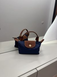 Blue Longchamp Le Pliage XS handbag with brown leather accents.
