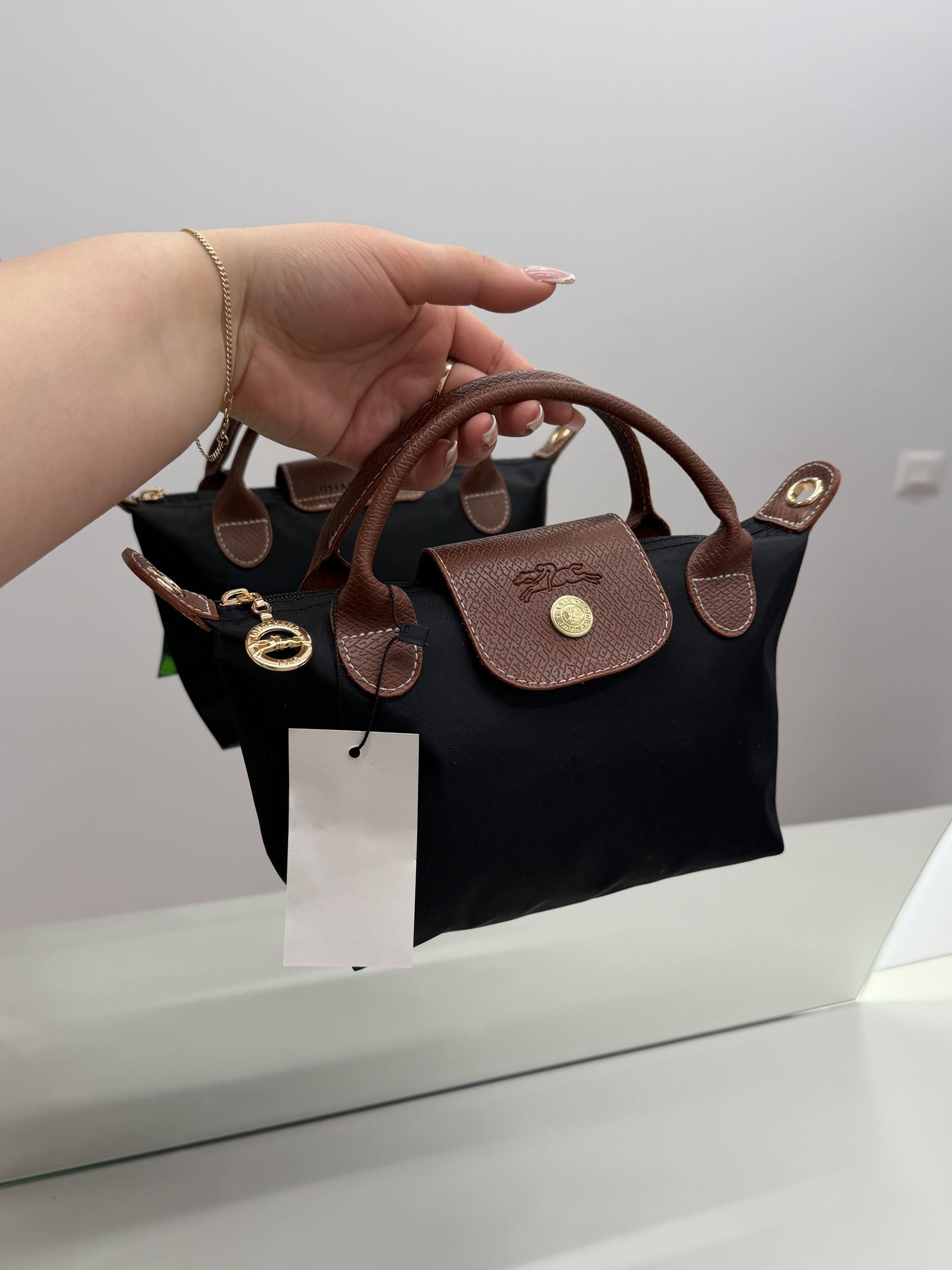 ds-canta-176-kryesore Çanta Femrash Longchamp Le Pliage XS, black with brown handles.