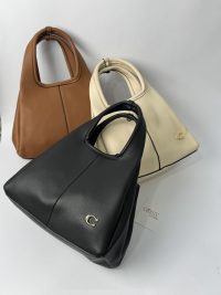 Coach Tote Bag me logo C in black, brown, and cream colors.