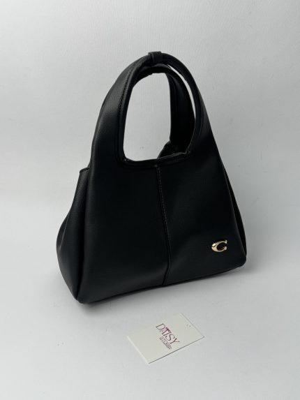 Black Coach Tote Bag with gold C logo on display.