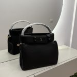 Çanta bucket with studded strap on mirrored surface.
