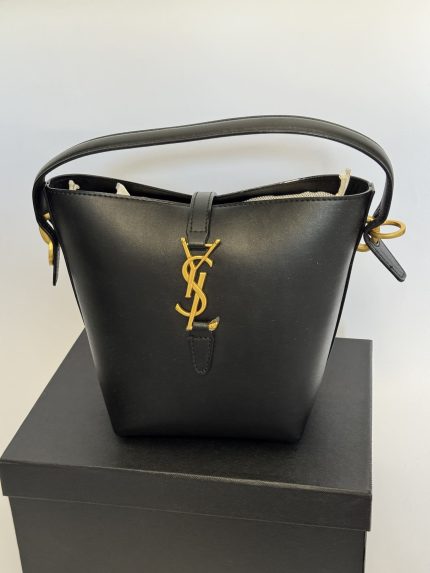 Elegant YSL black bucket bag with gold logo detail on box.