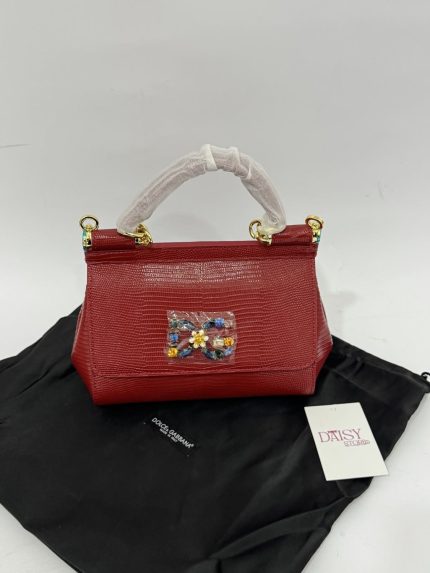 Red Dolce Gabbana Sicily handbag with jeweled accent on black cloth.