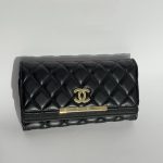 Black quilted women's wallet with gold accents.