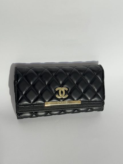 Black quilted women's wallet with gold accents.