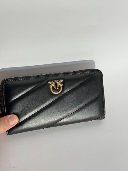 Elegant black Guess women's wallet with gold logo detail.