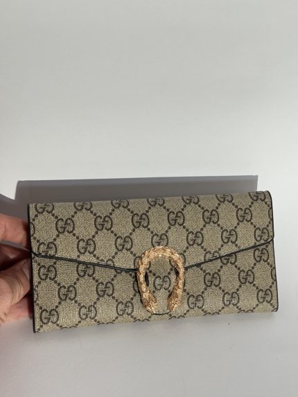 Elegant women's wallet with gold clasp and patterned design.