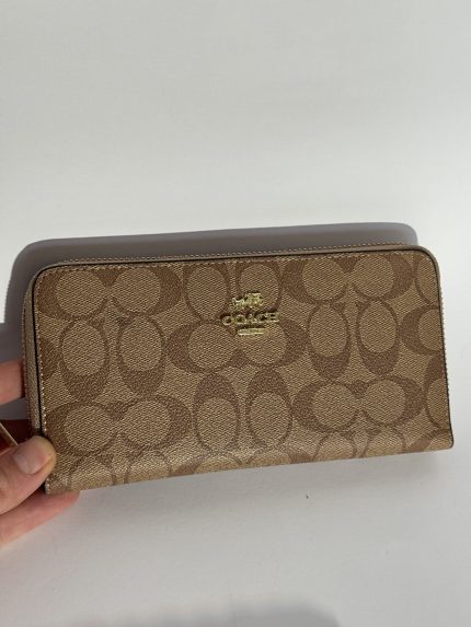 Brown patterned Louis Vuitton women's wallet on white background.