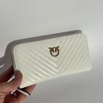 White Gucci women's wallet with gold logo, elegant design.