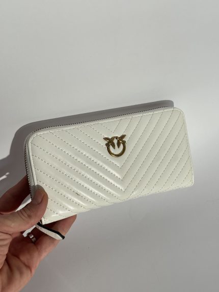 White Gucci women's wallet with gold logo, elegant design.