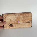 Elegant Goyard women's wallet with world map design.