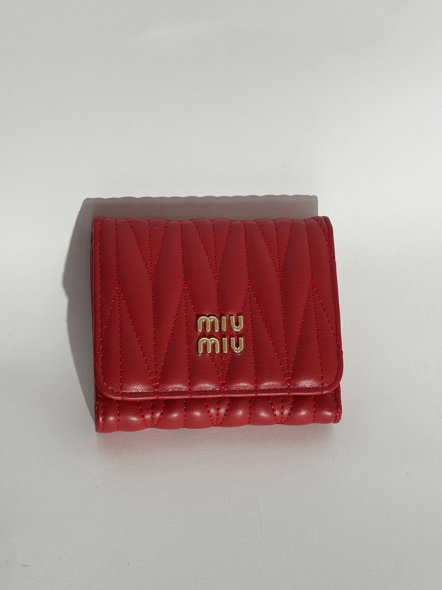 ds-portofola-026-kryesore Red quilted women's wallet with gold logo on white background.
