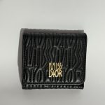 Black embossed women's wallet with gold logo detailing.