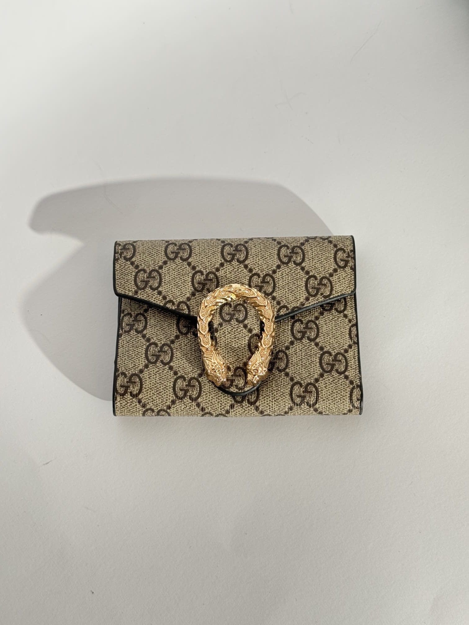 ds-portofola-038-kryesore Elegant Goyard women's wallet with patterned design and gold clasp.