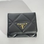 Black quilted leather wallet with gold logo emblem.