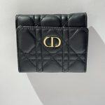 Black quilted women's wallet with gold emblem, elegant and stylish.