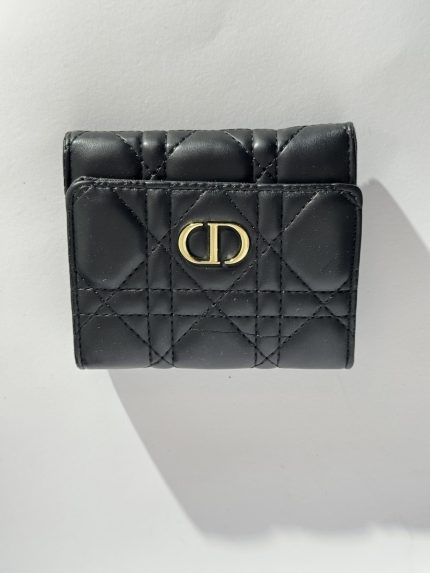 Black quilted women's wallet with gold emblem, elegant and stylish.