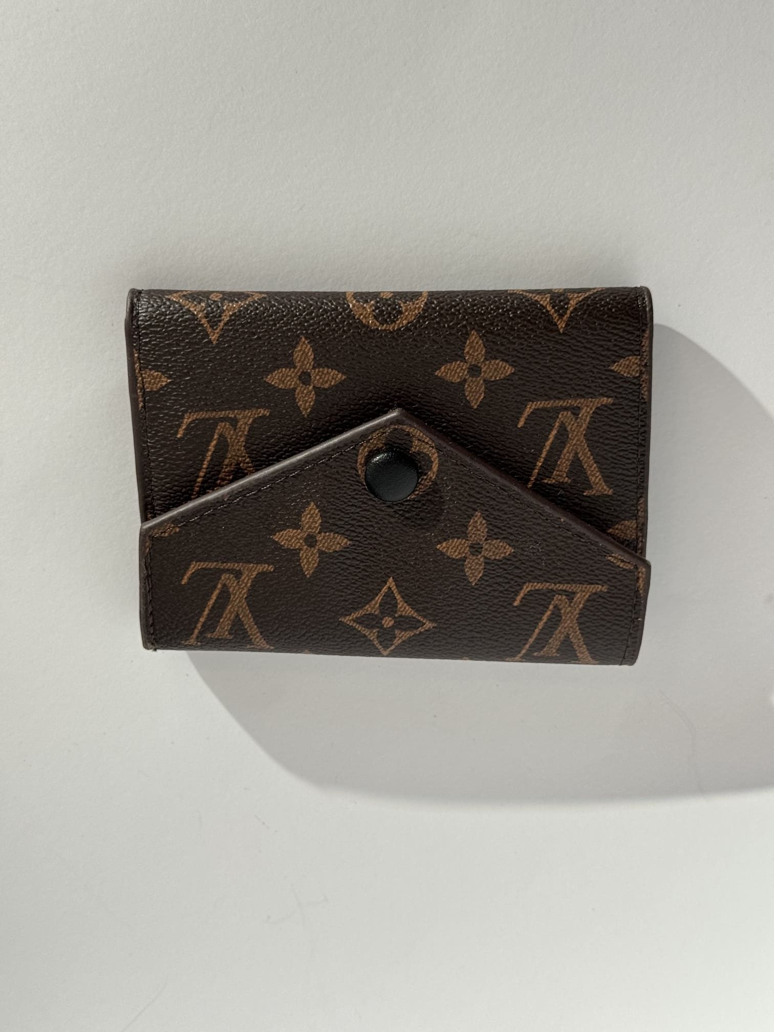 ds-portofola-047-kryesore Elegant brown patterned women's wallet with button closure.