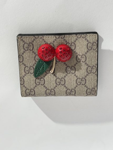 Gucci Portofol Femrash wallet with cherry embellishment on monogram canvas.