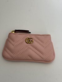 Pink Gucci Marmont zip pouch with gold logo and chevron design.