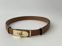 Hermes Kelly brown leather belt with gold buckle detail.
