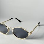 Elegant Gucci women's sunglasses with gold frames and dark lenses.