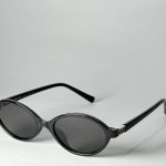 Black Gucci women's sunglasses with round lenses and gold accents.