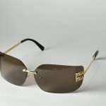 Elegant Gucci women's sunglasses with brown lenses and gold accents.