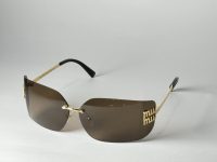 Elegant Gucci women's sunglasses with brown lenses and gold accents.