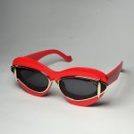 Red Gucci women's sunglasses with black lenses and gold accents.