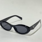 Black Prada women's sunglasses with oval lenses on white background.