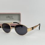 Gold YSL women's sunglasses with black lenses and case.