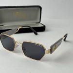 Christian Dior women's sunglasses with black lenses and gold frame.