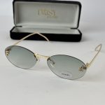 Gold-rimmed sunglasses with grey lenses and case, women's fashion accessory.