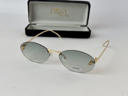 Gold-rimmed sunglasses with grey lenses and case, women's fashion accessory.