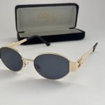 Gucci women's sunglasses with gold frame and dark lenses.