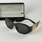 Prada women's sunglasses with black frames and gold accents.