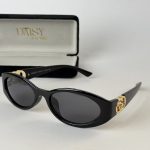 Black Prada women's sunglasses with gold accents and case.