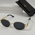 Celine women's sunglasses with gold frame and black lenses.