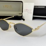 Miu Miu women's sunglasses with gold frame and black lenses.