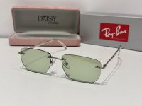 Ray-Ban sunglasses with green lenses and stylish metal frame.