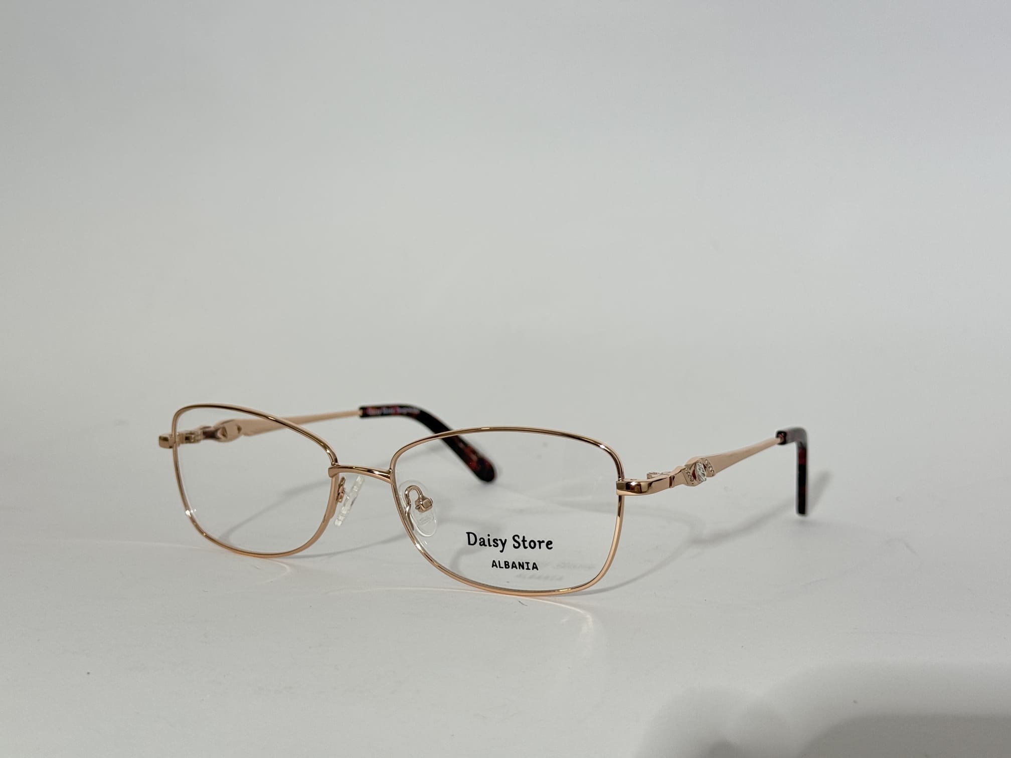 ds-syze-optike-071-kryesore Elegant women's optical frames with gold accents, Daisy Store branding.