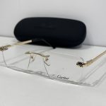 Skelete Optike Cartier rimless glasses with gold accents and case.