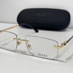 Gucci eyeglasses with gold accents and case, elegant design.