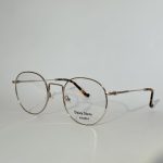 Elegant women's optical glasses with round frames and metal finish.