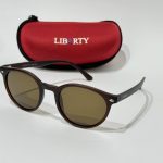 Syze Dielli Liberty Origjinale sunglasses with red case on white background.