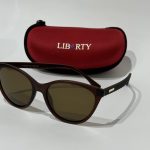 Syze Dielli Liberty Origjinale sunglasses with red case on white background.